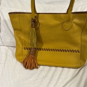 Sundance yellow pebbled vegan leather tote Bag with brown stitching and tassels.